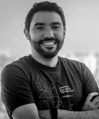 Black and white portrait of a smiling man with a dark beard.