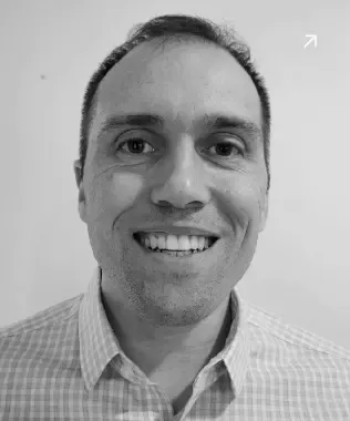 Black and white portrait of a smiling man with glasses and a beard.