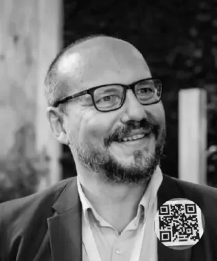 Black and white headshot of a smiling man in a suit.