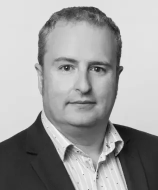 Black and white headshot of a smiling woman with dark, long hair.