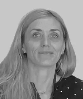 Black and white headshot of a smiling woman with dark hair.