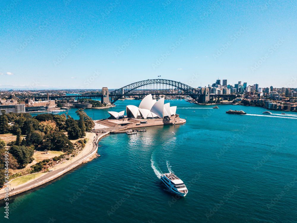Aerial view of Sydney Harbour with the iconic Opera House, Harbour Bridge, and city skyline.