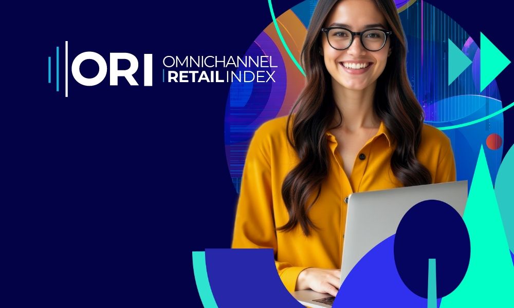 Smiling woman wearing glasses, working on a laptop, with ORI Omnichannel RetailIndex.
