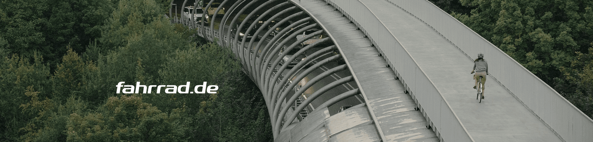 Person cycles on a modern curved bridge above green trees. Text: fahrrad.de.