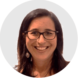 Smiling woman with dark hair and glasses in a circular professional headshot.