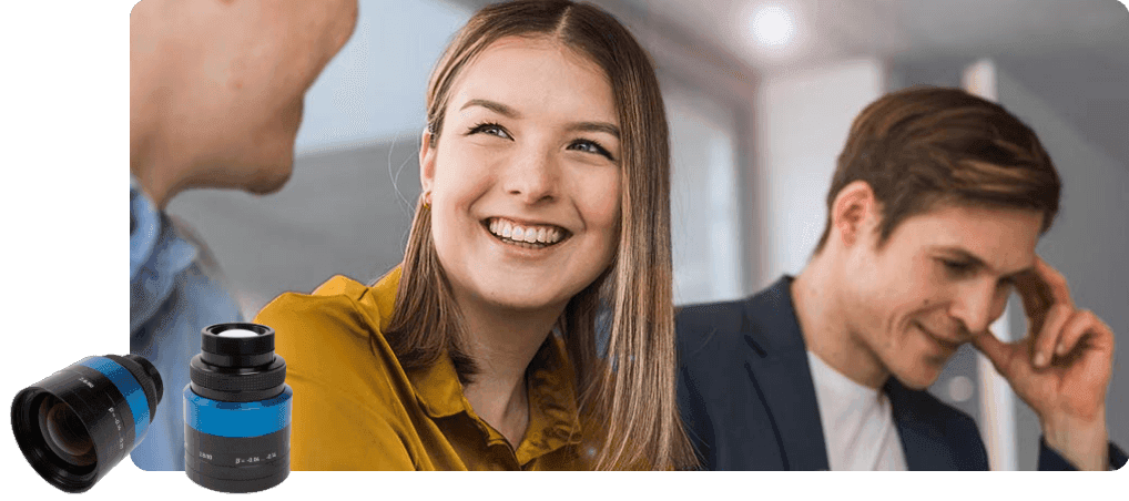 Happy colleagues discussing a project with camera lenses in foreground.