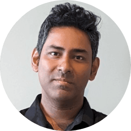 Professional headshot of a man with dark wavy hair and a dark shirt.
